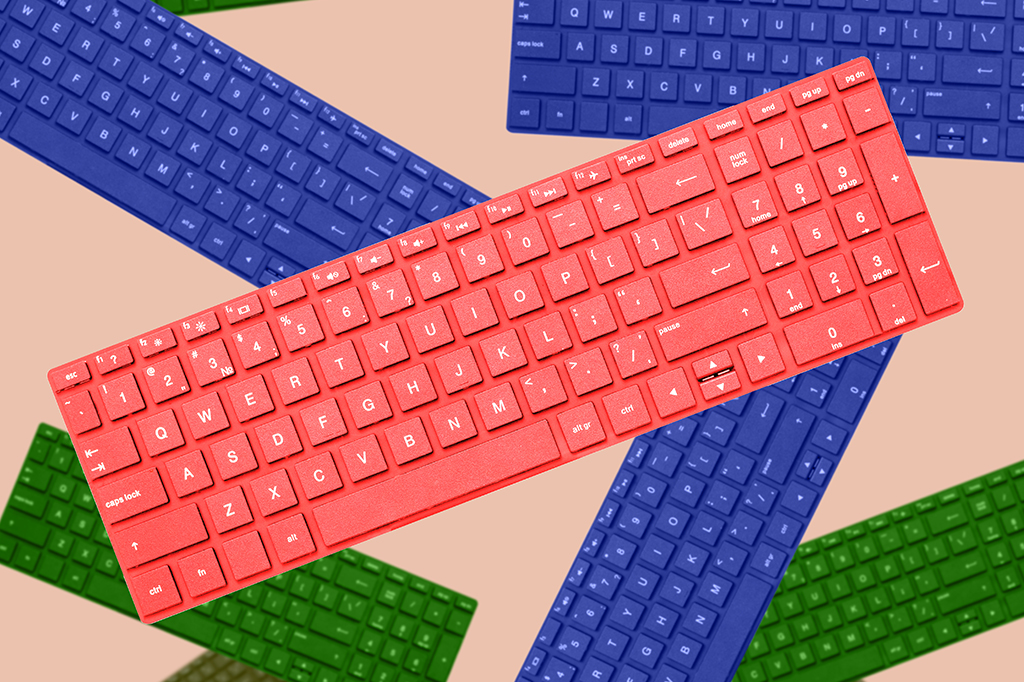 Vários teclados coloridos, um vermelho em destaque no centro, com outros azuis e verdes espalhados sobre um fundo bege